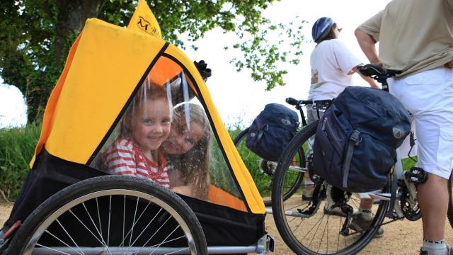 En famille sur les Voies Vertes avec des enfants dans une cariole aménagée