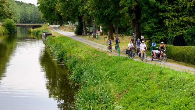 Cyclotouristes le long du Canal de Nantes à Brest. Port-de-Carhaix : jonction avec les Voies Vertes 6 et 7. La Vélodyssée